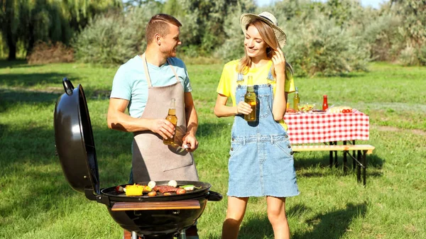 Un cuplu fericit gătește mâncare pe grătar în parc — Fotografie, imagine de stoc