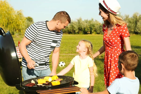 Familie fericită cu copii mici care au grătar în parc — Fotografie, imagine de stoc