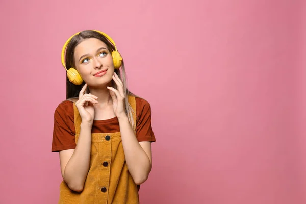 Χαρούμενη έφηβη με ακουστικά σε ροζ φόντο. Χώρος για κείμενο — Φωτογραφία Αρχείου