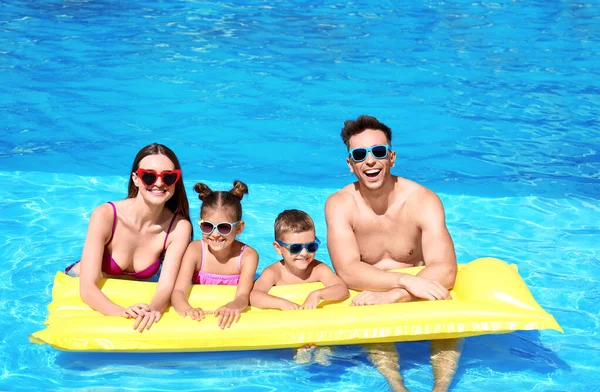 Famiglia felice con materasso gonfiabile in piscina — Foto Stock