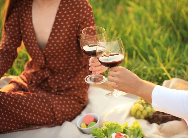 Jong stel met wijn picknick in groen park, close-up — Stockfoto