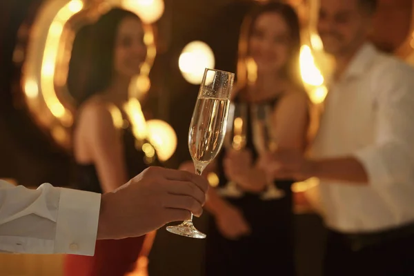 Hombre sosteniendo una copa de champán en la fiesta de Año Nuevo, primer plano —  Fotos de Stock