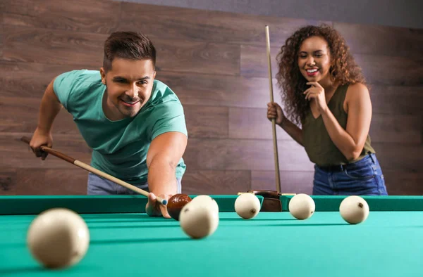 Young man and woman playing billiard indoors — Stock Photo, Image