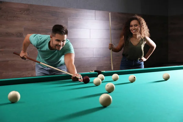 Young man and woman playing billiard indoors — Stock Photo, Image