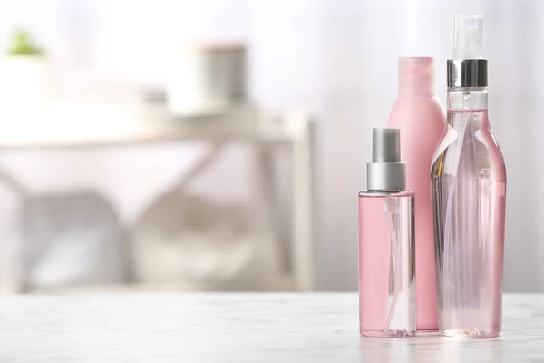 Пляшки з косметикою для догляду за волоссям на столі у ванній, простір для тексту — стокове фото