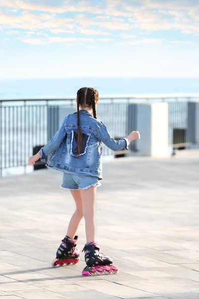 Little girl roller skating on city street — Stock Photo, Image