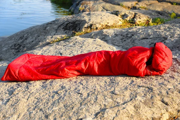 晴れた日に湖の近くの寝袋で休んでいる女性 — ストック写真