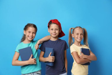 Mavi arka plan kitapları olan küçük çocuklar. Okuma konsepti