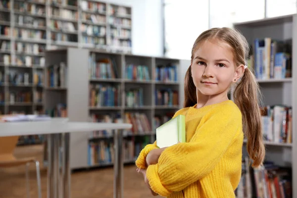 Menina bonito com livros na sala de leitura da biblioteca — Fotografia de Stock