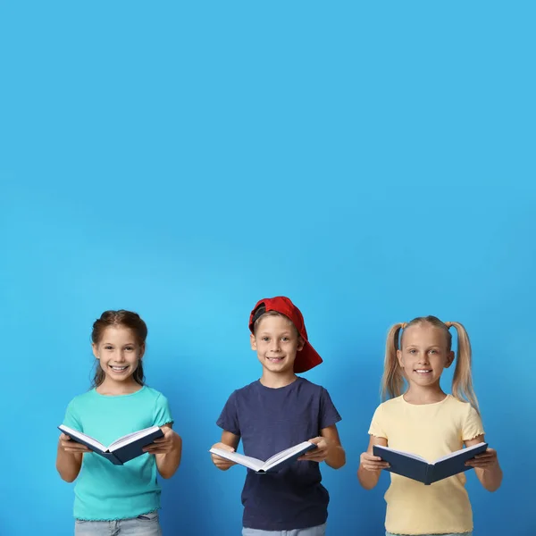 Retrato de niños leyendo libros sobre fondo azul — Foto de Stock