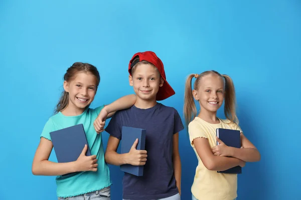 Niños pequeños con libros sobre fondo azul. Concepto de lectura — Foto de Stock