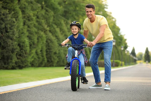 Papa enseigne à son fils à faire du vélo à l'extérieur — Photo