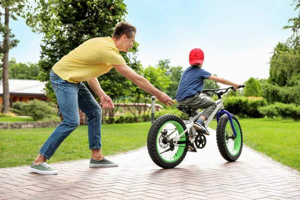 Papa enseigne à son fils à faire du vélo à l'extérieur — Photo