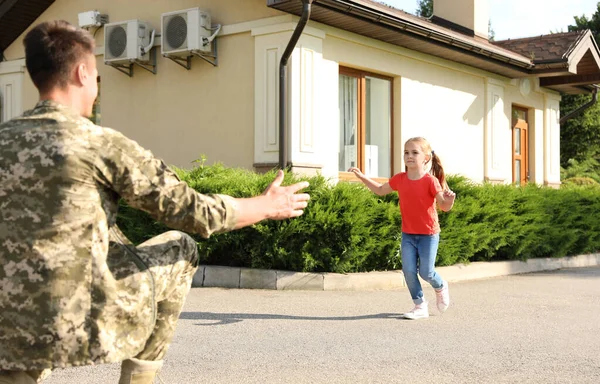 Az apja katonai egyenruhában, a kislánya pedig a szabadban rohan hozzá. — Stock Fotó