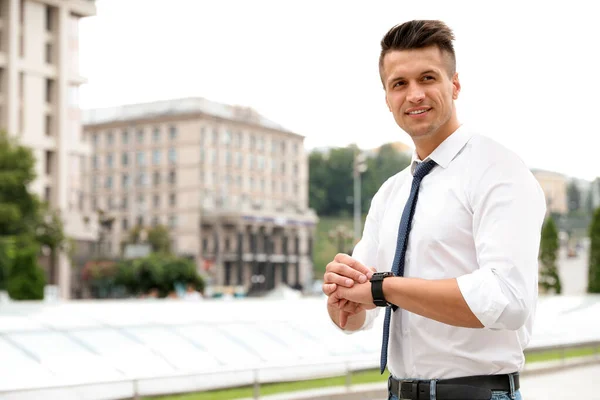 Porträt eines gutaussehenden jungen Mannes, der die Zeit auf der Straße kontrolliert. Raum für Text — Stockfoto