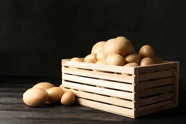 Raw fresh organic potatoes on wooden table against dark background. Space for text — Stock Photo, Image