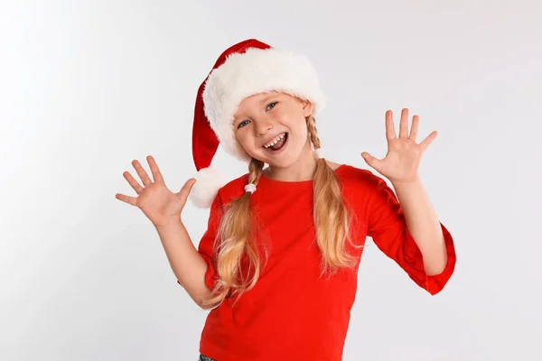 快乐的小孩戴着浅灰背景的圣诞老人帽. 圣诞节庆祝活动 — 图库照片