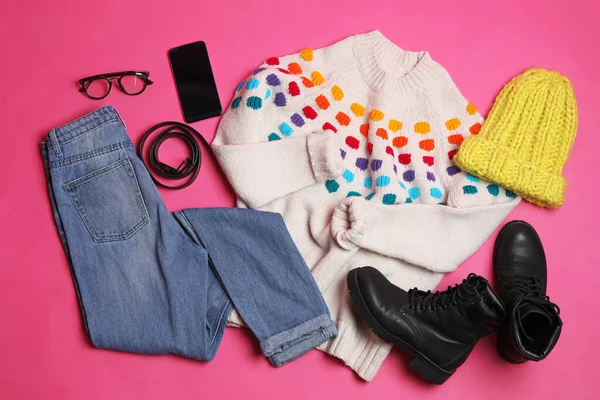 Composición plana con ropa de invierno y botas sobre fondo rosa —  Fotos de Stock