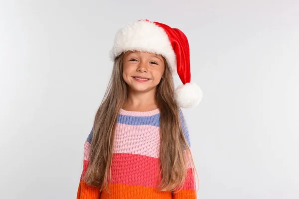 Щаслива маленька дитина в Санта-Каті на світло-сірому фоні. Свято Різдва — стокове фото