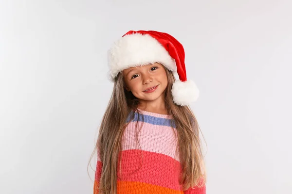 Щаслива маленька дитина в Санта-Каті на світло-сірому фоні. Свято Різдва — стокове фото