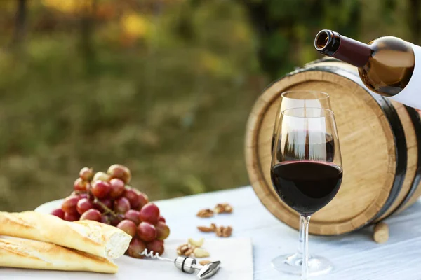 Composizione con vino e snack su tavolo bianco in legno all'aperto — Foto Stock