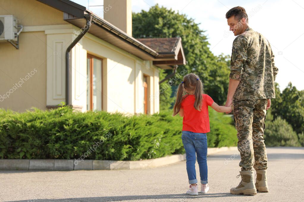 Father in military uniform with his little daughter outdoors