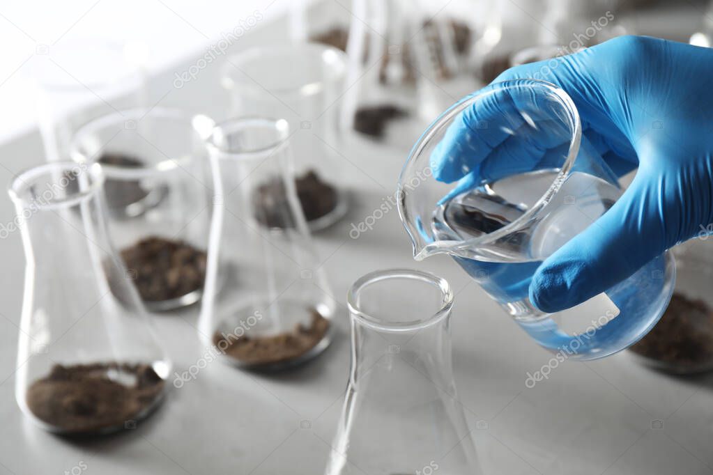 Scientist preparing soil extract at table, closeup. Laboratory research