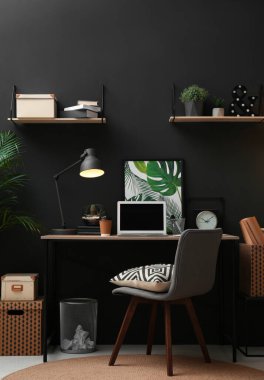 Masasında modern dizüstü bilgisayarı olan rahat bir iş yeri. Merkez Ofis