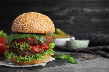 Gri masada et pirzolası olan lezzetli bir burger. Metin için boşluk