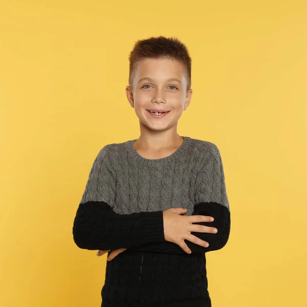 Menino bonito em camisola quente no fundo amarelo. Temporada de Inverno — Fotografia de Stock