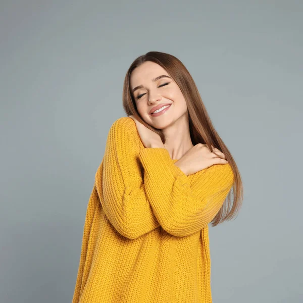 Bella giovane donna in maglione giallo su sfondo grigio. Stagione invernale — Foto Stock