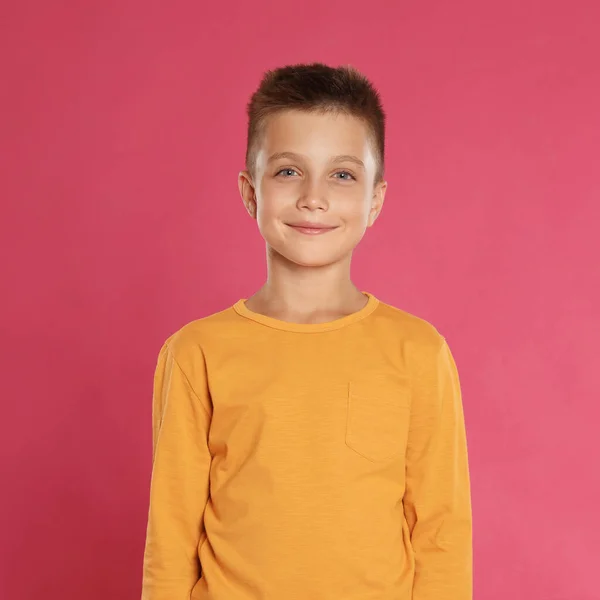 Schattig jongetje poseren op roze achtergrond — Stockfoto