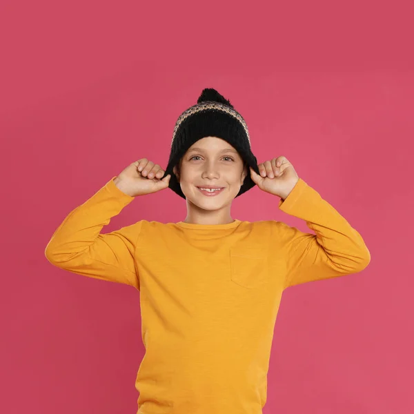 Söt liten pojke i varm hatt på rosa bakgrund. Vintersäsong — Stockfoto
