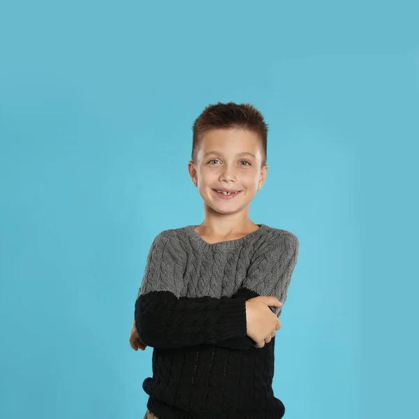 Menino bonito em camisola quente no fundo azul, espaço para texto. Temporada de Inverno — Fotografia de Stock