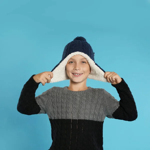 Menino bonito em suéter e chapéu no fundo azul. Temporada de Inverno — Fotografia de Stock