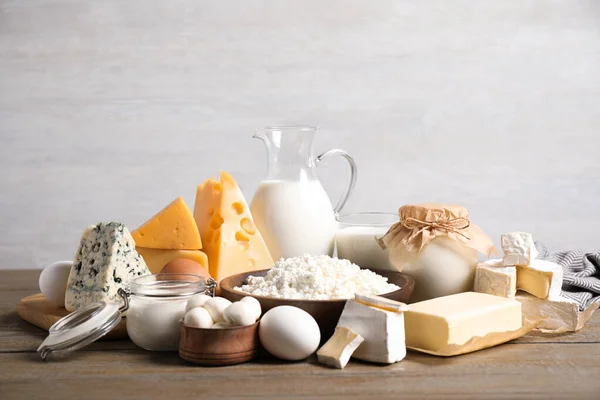 Diferentes deliciosos produtos lácteos na mesa de madeira — Fotografia de Stock