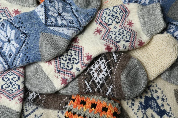 Différentes chaussettes en laine tricotées comme fond, gros plan — Photo