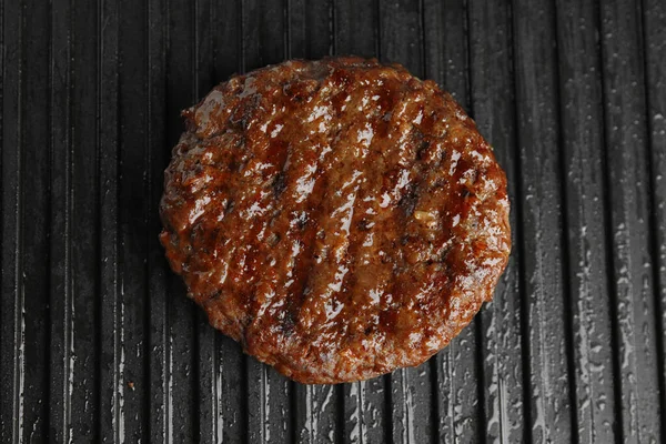 Gotowy kotlet mięsny na hamburgera na grillu, zbliżenie — Zdjęcie stockowe