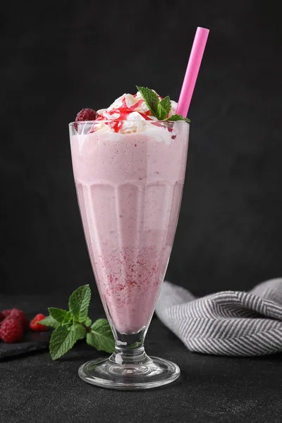 Sabroso batido de leche fresca en vaso sobre mesa negra —  Fotos de Stock