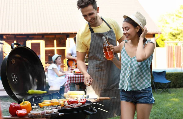 Giovane uomo e donna vicino barbecue all'aperto — Foto Stock