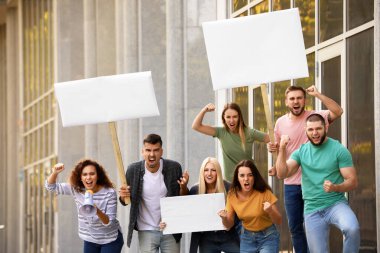 Kızgın Afro-Amerikalı kadın megafonla dışarıda protesto yapıyor.