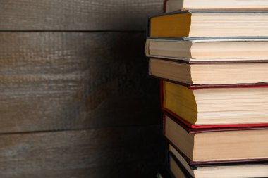 Ahşap arka planda bir yığın ciltli kitap, yakın plan. Metin için boşluk