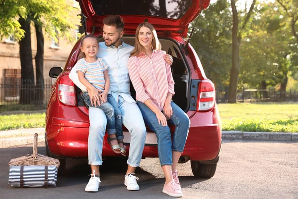 Boldog család ül a kocsi csomagtartójában a szabadban — Stock Fotó