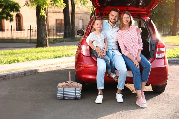 Gelukkig gezin zittend in de kofferbak buiten — Stockfoto