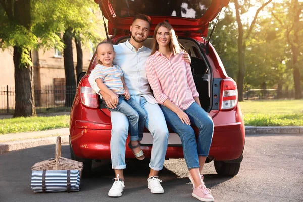 Boldog család ül a kocsi csomagtartójában a szabadban — Stock Fotó