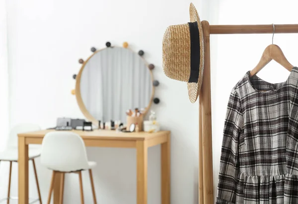 Hanger met stijlvolle doek en hoed op rek in de make-up kamer. Ruimte voor tekst — Stockfoto