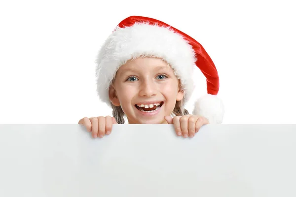 Glückliches Kind mit Weihnachtsmütze, das aus einem leeren Banner auf weißem Hintergrund hervorlugt. Weihnachtsfeier — Stockfoto