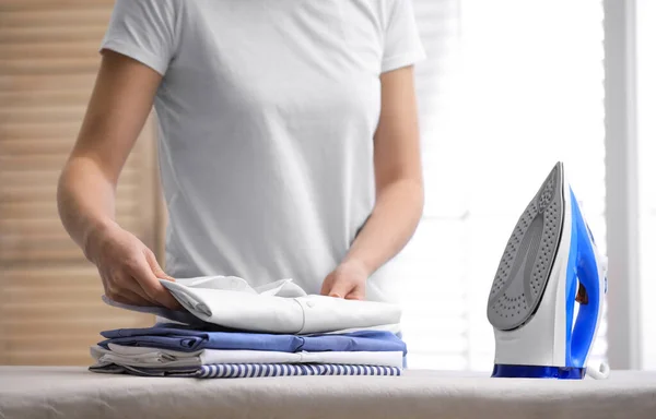 Mujer joven planchando camisa limpia en casa, primer plano. Día de lavandería — Foto de Stock