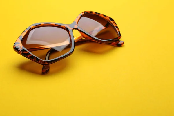 Snygga solglasögon på gul bakgrund, utrymme för text. Fashionabla tillbehör — Stockfoto