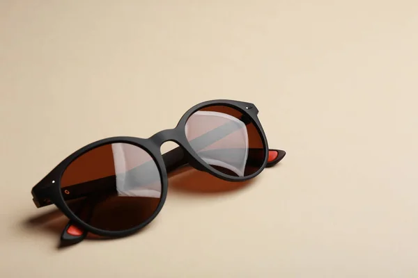 Lunettes de soleil élégantes sur fond beige. Accessoire tendance — Photo